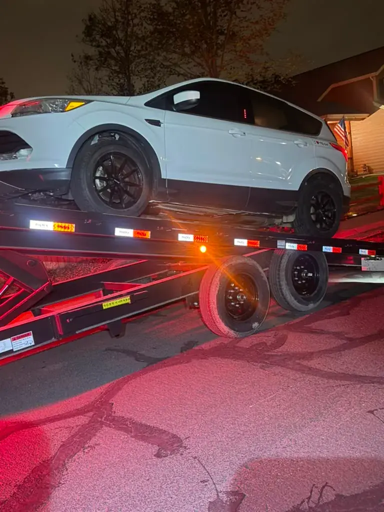 Vehicle transported on a car hauler trailer at night